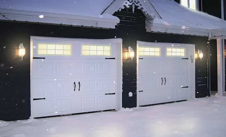 Maison bleue de style traditionnel en hiver, incluant un garage double avec portes de garage Standard+ North Hatley SP Blanc glacier de grandeur 9' x 7'.