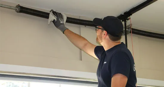 Garage door expert doing maintenance on garage door springs